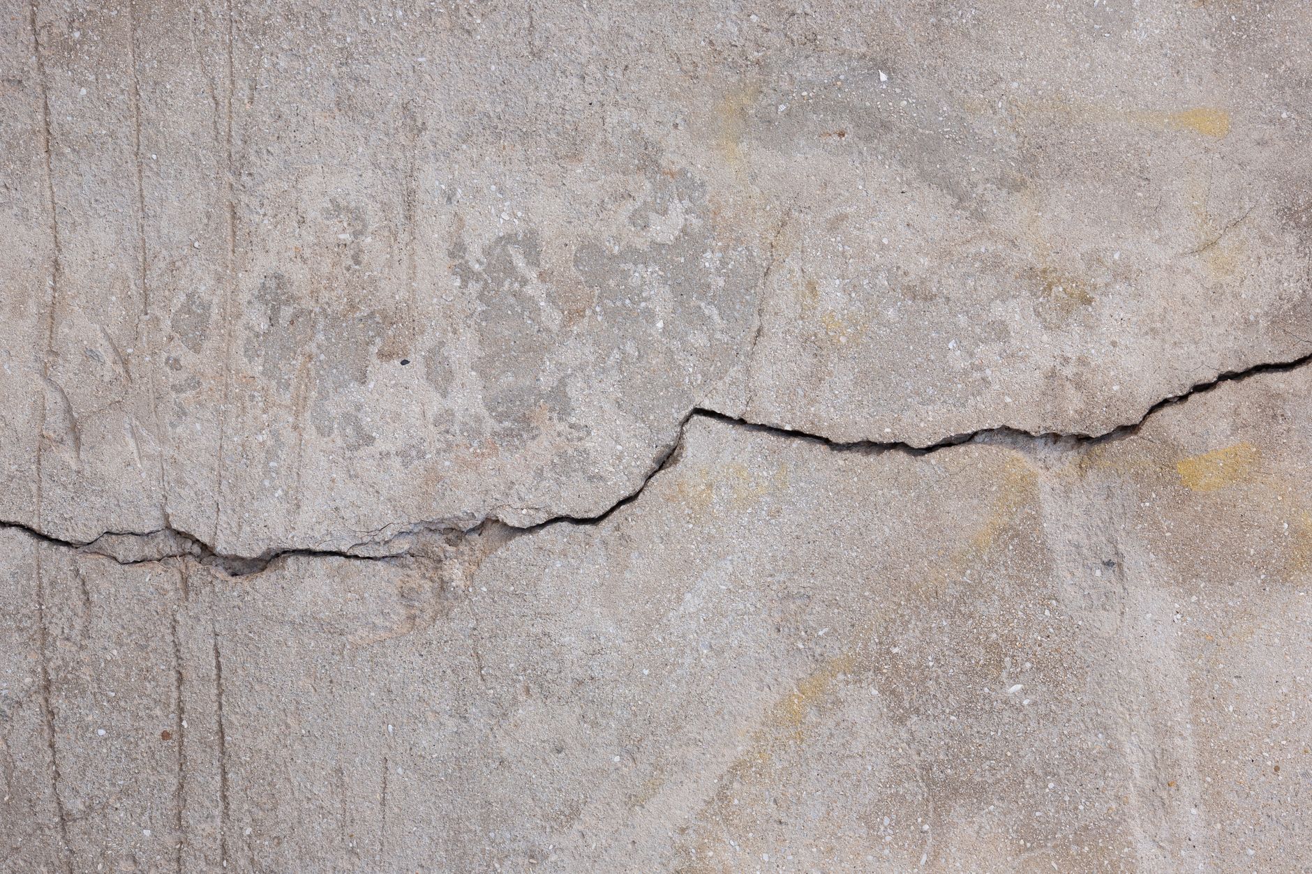 Wide crack running across a weathered concrete surface