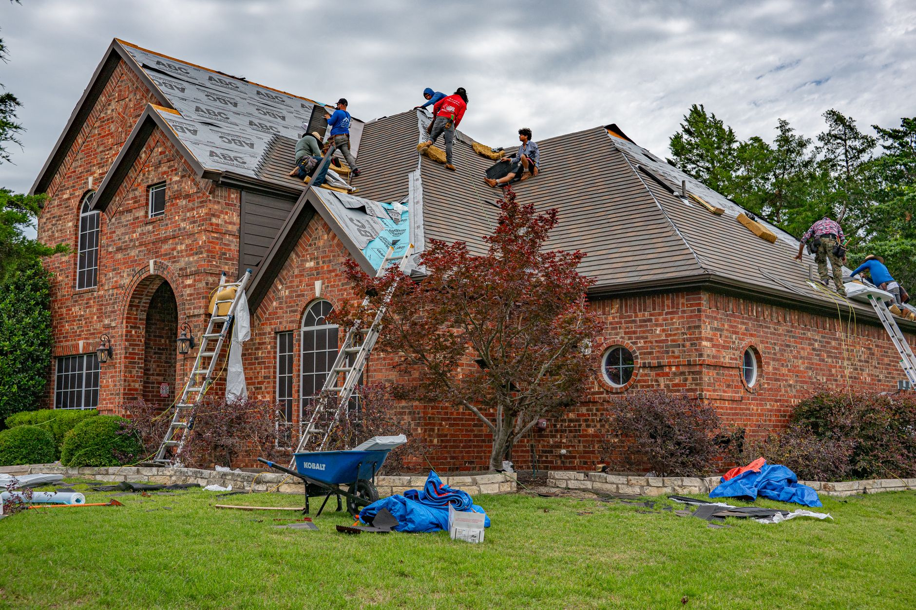 Roofing crew replacing the roof covering on a large building